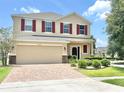 Charming two-story home with a brick-paved driveway and well-manicured lawn at 16334 Saint Augustine St, Clermont, FL 34714