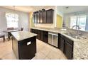 Kitchen featuring granite countertops, stainless steel appliances, dark cabinets, and center island at 16334 Saint Augustine St, Clermont, FL 34714