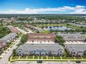 Picturesque aerial view showcasing a community with a central pond and lush landscaping at 16724 Cedar Crest Dr, Orlando, FL 32828