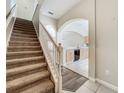 Warm entryway features carpeted stairs, arched doorways, and a view into the kitchen at 16724 Cedar Crest Dr, Orlando, FL 32828