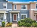 Inviting townhome entrance featuring a covered porch, brick walkway, and lush landscaping at 16724 Cedar Crest Dr, Orlando, FL 32828