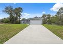 Well-maintained single-story home with a concrete driveway and lush green lawn at 16904 Sw 30Th Avenue Rd, Ocala, FL 34473
