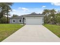 Well-maintained single-story home with a concrete driveway and lush green lawn at 16904 Sw 30Th Avenue Rd, Ocala, FL 34473