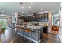 Modern kitchen with stainless steel appliances, dark cabinetry, a large island and barstool seating at 17840 Passionflower Cir, Clermont, FL 34714