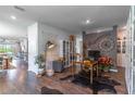 Open-concept living area featuring hardwood floors, neutral paint, designer decor, and lots of natural light at 17840 Passionflower Cir, Clermont, FL 34714
