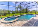 Relaxing screened-in outdoor pool and jacuzzi area with views of a serene lake and green space at 17840 Passionflower Cir, Clermont, FL 34714