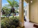 A column frames the view of the exterior, showcasing lush landscaping and a charming neighborhood street at 2026 Winding Oaks Dr, Orlando, FL 32825