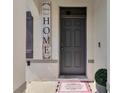 Inviting front entrance featuring a stylish gray door and a decorative 'HOME' sign at 269 Ludisia Loop, Davenport, FL 33837