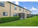 Townhome backyard featuring a lush lawn, privacy landscaping, and screened patios at 2936 Econ Landing Blvd, Orlando, FL 32825