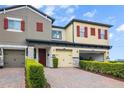 Townhome exterior with colorful facades, attached garages, and well-maintained landscaping at 2936 Econ Landing Blvd, Orlando, FL 32825