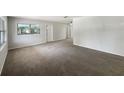 Spacious, carpeted living room featuring neutral walls, windows, and a doorway for easy flow at 300 Avenue E Se, Winter Haven, FL 33880
