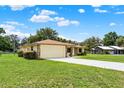 Spacious single-story home featuring an attached two-car garage, long driveway and a well-maintained lawn at 409 Jumper S Dr, Bushnell, FL 33513