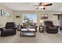 Cozy living room featuring comfortable leather seating, neutral carpeting, and lots of natural light at 409 Jumper S Dr, Bushnell, FL 33513