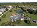 Aerial view of the home and the large treed lot featuring a serene pond. The back of the house can be seen at 4121 High Plains Ln, Kissimmee, FL 34744
