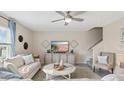 Bright living room with a ceiling fan, comfortable seating, and a staircase at 4706 Golden Knight Blvd, Kissimmee, FL 34746