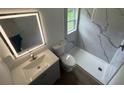 Modern bathroom features stylish tile shower and updated vanity with mirror at 506 South St, Daytona Beach, FL 32114