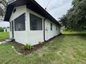 Side view of the home features freshly painted exterior, manicured lawn, and new landscaping at 506 South St, Daytona Beach, FL 32114