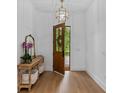 Bright entryway with hardwood floors, console table, gold mirror, and statement light fixture at 5237 Haverill Dr, Orlando, FL 32809