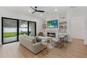 Open concept living room featuring a modern fireplace, recessed lighting, large windows and hardwood floors at 5237 Haverill Dr, Orlando, FL 32809