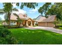 Charming home with a well-manicured lawn, mature trees, and a spacious driveway at 5950 Blakeford Dr, Windermere, FL 34786