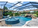 Screened-in pool with spa, waterfall, and golf course views offers a private oasis at 5950 Blakeford Dr, Windermere, FL 34786