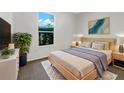 Modern bedroom with a queen-size bed, stylish decor, and a large window offering plenty of natural light at 704 Pickfair Ter, Lake Mary, FL 32746