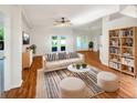 Bright living room with hardwood floors, plush seating, and French doors leading to the backyard at 704 Pickfair Ter, Lake Mary, FL 32746