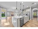 Modern kitchen with island, stainless appliances, and open layout flowing into a living area with fireplace at 808 Sherbourne Cir, Lake Mary, FL 32746