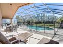 Relaxing screened-in pool area with lounge chairs, patio furniture, and a view of the backyard at 927 Orange Cosmos Blvd, Davenport, FL 33837