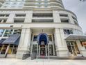 Elegant condominium entrance with a covered walkway, glass doors, and convenient access to shops at 100 S Eola Dr # 611, Orlando, FL 32801