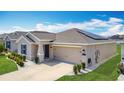 Lovely one-story home featuring a two-car garage, manicured lawn, and a solar panel system on the roof at 1120 Saguaro St, Haines City, FL 33844