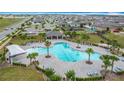 Aerial view of community pool and amenities featuring chairs, umbrellas and ample greenery around pool at 1120 Saguaro St, Haines City, FL 33844