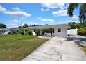Classic single-story home with a gray roof, a large driveway, and landscaped shrubbery at 1216 Floral Way, Apopka, FL 32703