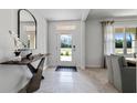 Inviting entryway with light tile flooring, modern console table, and view to the front door at 1495 Fountain View St, Ormond Beach, FL 32174
