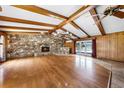 Spacious living room with hardwood floors, a stone fireplace, and wood paneled walls at 1508 Lake Mills Rd, Chuluota, FL 32766