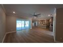 Open-concept living area featuring wood flooring, a ceiling fan, and access to the kitchen at 160 Steeplechase Cir, Sanford, FL 32771