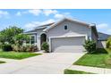 Attractive one-story home featuring manicured landscaping, and a two-car garage at 17200 Gathering Place Cir, Clermont, FL 34711