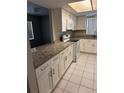 Updated kitchen showcases granite counters, white cabinets, and tiled floors at 2408 Swailes Dr # 6, Orlando, FL 32837