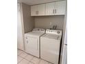 Functional laundry area equipped with a washer, a dryer, and overhead cabinet storage at 2408 Swailes Dr # 6, Orlando, FL 32837