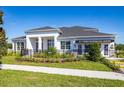 Charming home featuring a manicured lawn, dark roof, a black metal fence, and white columns at 2739 Ravencliffe Ter, Oviedo, FL 32765