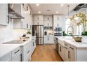 Modern kitchen boasts white cabinets, stainless steel appliances, a kitchen island and hardwood floors at 2739 Ravencliffe Ter, Oviedo, FL 32765