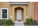 Close-up of an inviting townhome entrance with a white door and manicured landscaping at 3019 White Orchid Rd, Kissimmee, FL 34747