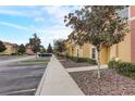 Street view of townhomes with colorful facades and meticulous landscaping under a bright sky at 3019 White Orchid Rd, Kissimmee, FL 34747