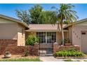 Close-up of a charming home's entry with brick accents and a secure gate at 3121 Thistlehill Drive, Winter Park, FL 32792