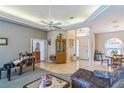 Open-concept living area featuring a grand piano, tile floors, and a tray ceiling with a ceiling fan at 34239 Woodridge Ln, Eustis, FL 32736