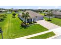 Aerial view of a well-kept single-story home with 3-car garage and inviting front porch with a green lawn at 3630 Trimaran Dr, Orlando, FL 32820