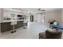 Open-concept living space features a kitchen with bar seating, modern floors, and a sliding barn door at 410 W Seminole Ave, Eustis, FL 32726