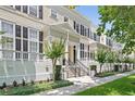 Attractive two-story townhouse with black shutters, lush landscaping, and inviting front porch at 476 Water St, Celebration, FL 34747