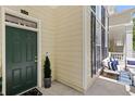 Inviting front porch with a cozy seating area, a dark green front door, and manicured landscaping at 476 Water St, Celebration, FL 34747