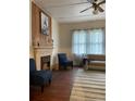 Cozy living room featuring a decorative fireplace, wood floors, and comfortable blue seating at 485 Palm St, Winter Garden, FL 34787